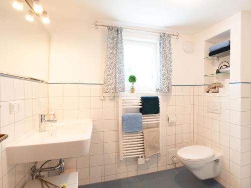 a bathroom with a sink and a toilet and a window at Gästehaus Minkel in Gudensberg