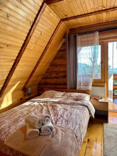 a bedroom with a bed with towels on it at VILA LENA in Kokin Brod