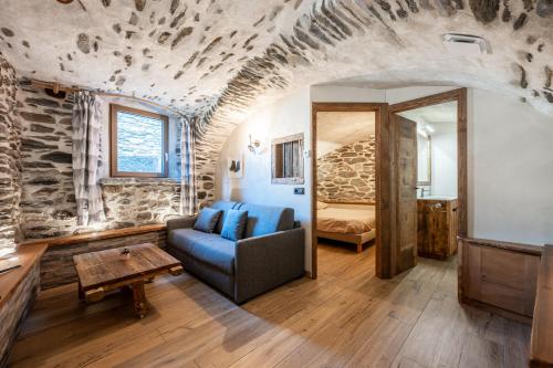 a living room with a blue couch and a bedroom at Appartement ô Canton in Val Cenis