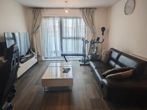 a living room with a couch and a coffee table at Cozy 1 Bedroom Apartment Retreat in West Thurrock