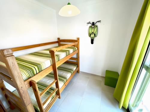 Zimmer mit 2 Etagenbetten und einem Roller an der Wand in der Unterkunft Casa Tété in Benagil