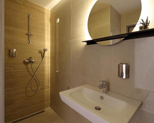 a bathroom with a sink and a mirror at Hotel Koncept Residence in Sarajevo