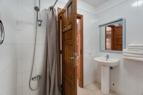een badkamer met een douche, een wastafel en een deur bij Alondras Apartamento E107 in Costa Del Silencio