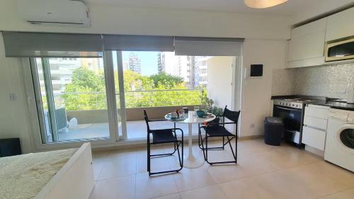 a kitchen with a table and chairs and a window at Monoambiente encantador en Nuñez in Buenos Aires