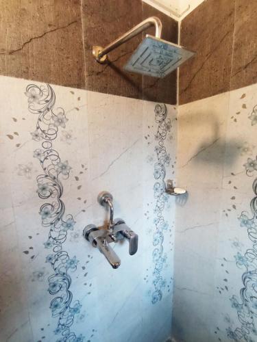 a shower with a faucet in a bathroom at Farm house in danda gaun, shivapuri in Kathmandu