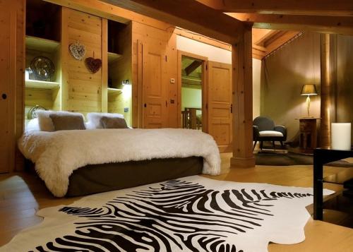a bedroom with a bed with a zebra print rug at Chalet Luxury 5-Les Gets-Luxe-confort-jacuzzi-à 400 m des pistes et vue montagne Mont Chéry in Les Gets