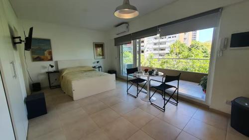 a bedroom with a bed and a table and chairs at Monoambiente encantador en Nuñez in Buenos Aires