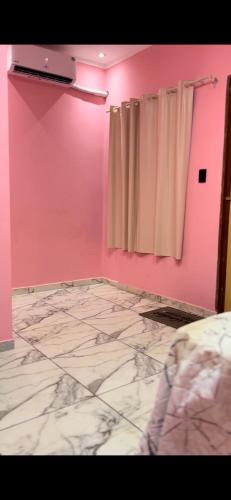 a bedroom with a pink wall and a curtain at Casa alter oficial in Alter do Chao