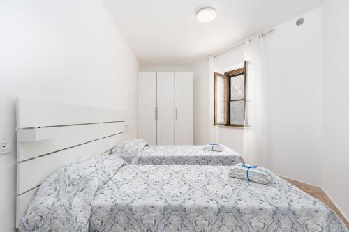 オロゼーイにあるVilla acquamarinaの白い壁の部屋にベッドが2つある