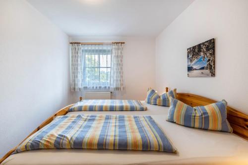 a bedroom with two beds and a window at Fewo Brünnstein - Nr 61 Pool, Sauna in Oberaudorf