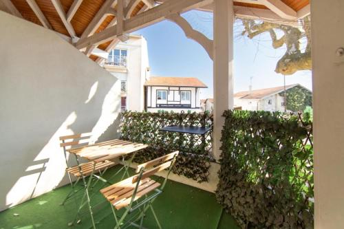 アンデルノ・レ・バンにあるAppartement Thiers in Andernosのパティオ(椅子、テーブル、フェンス付)