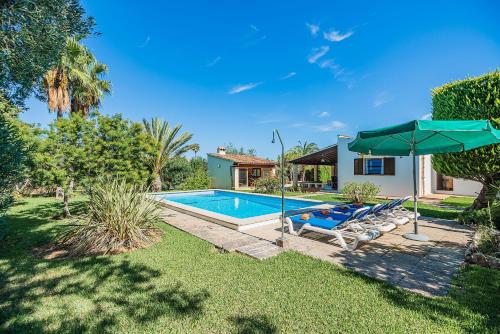 a pool with two lounge chairs and an umbrella at Villa Moreno in Pollença