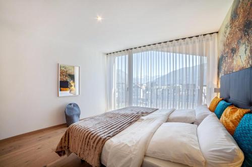 ナトゥルノにあるAdler Living Attika Wohnungの大きなベッドと大きな窓のある寝室