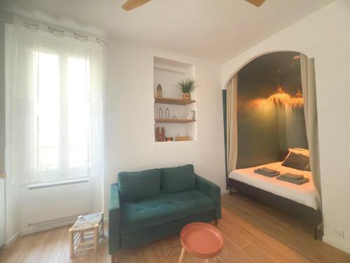 a living room with a green couch and a bed at Mourillon proche plages in Toulon