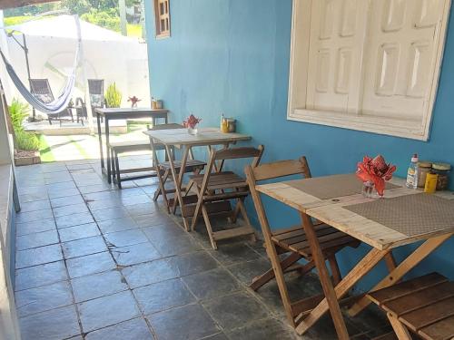 a dining room with tables and chairs and a door at Casa Beija-flor Pousada in Ilha de Boipeba