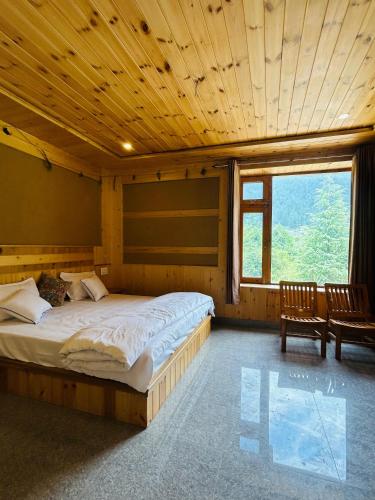 a bedroom with a large bed with a wooden ceiling at Himalayan Baseraa in Sainj