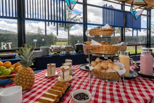 a table with baskets of food on a red and white checked table cloth at Pop Art Hotel Tocancipá y Centro de Convenciones in Tocancipá
