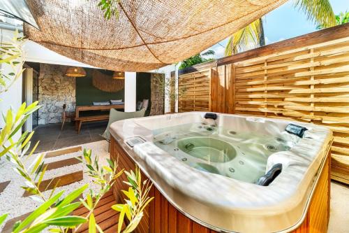 eine Whirlpool-Badewanne in der Mitte einer Terrasse in der Unterkunft Villa Naroli-7pers-Jacuzzi-Plage in La Saline