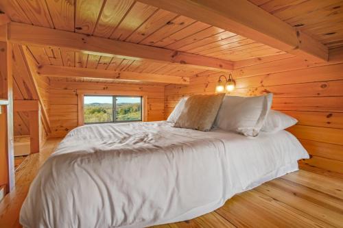 a bedroom with a bed in a log cabin at Panoramic Paradise - Hot Tub in Brookville