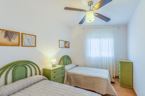 ein Schlafzimmer mit zwei Betten und einem Deckenventilator in der Unterkunft A222 El Recreo in Torrox