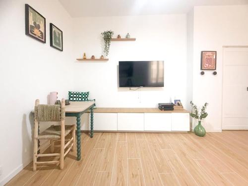 a living room with a table and a tv on a wall at Mourillon proche plages in Toulon