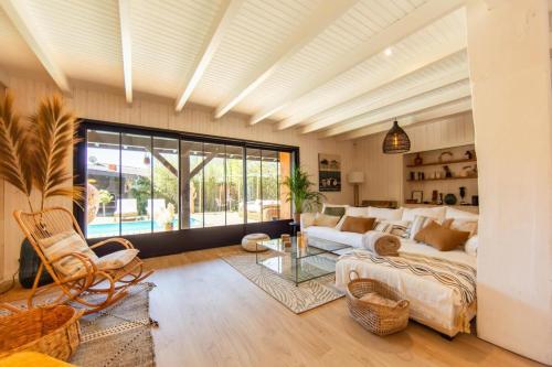 a living room with a couch and a table at Villa Alhena à Lège with heated swimming pool in Lège-Cap-Ferret