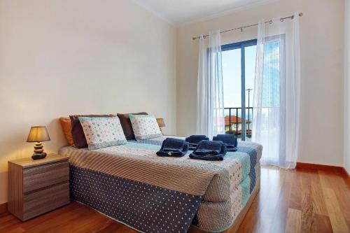 a bedroom with a bed and a large window at Moradia Casa Feliz in Santa Cruz