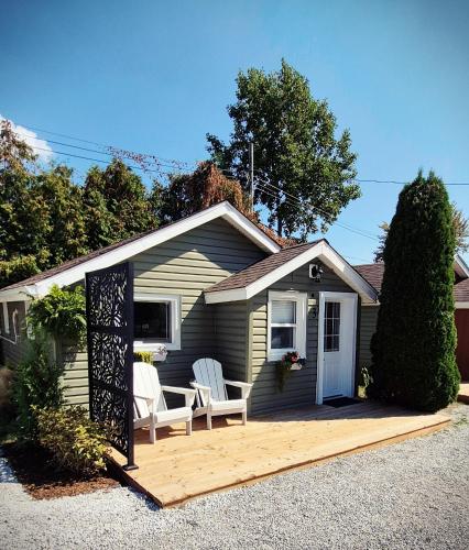a house with two chairs and a wooden deck at Parkview Boho Cottage 3 - Maple Meadows in Leamington