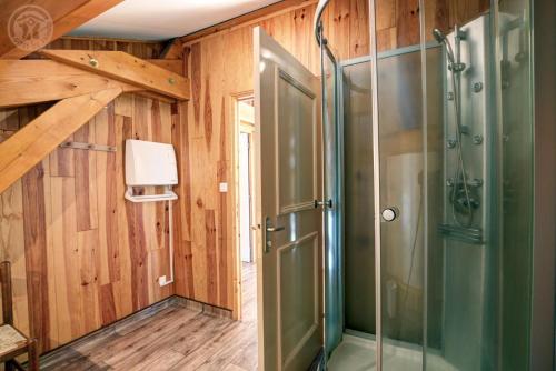 a shower with a glass door in a bathroom at Gite de la croix in Apinac