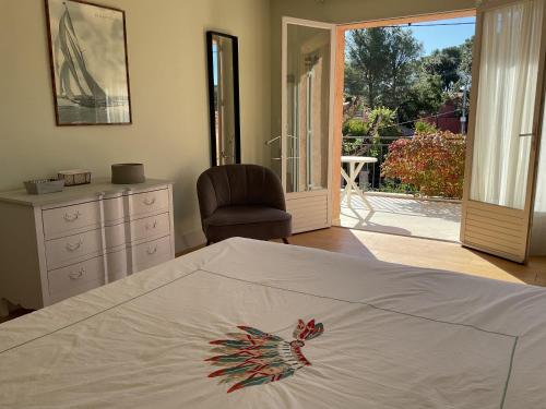 a bedroom with a bed with a dresser and a chair at Les cigales in Saint-Raphaël