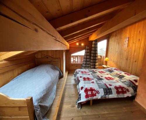 a bedroom in a log cabin with a bed at Les Dolomites in La Plagne Tarentaise