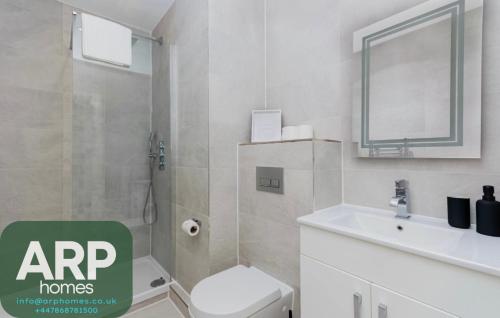 BuckinghamshireにあるElegant Central, Private Parking, Leisure, Contractorの白いトイレと洗面台のあるバスルーム