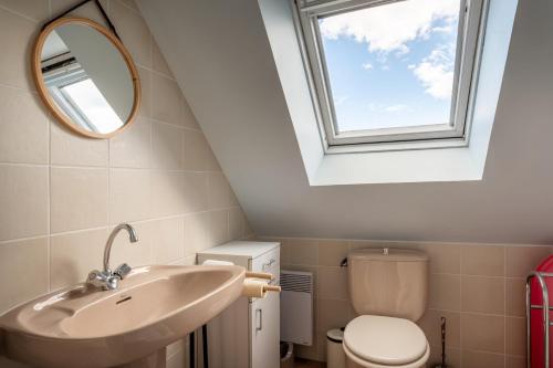 a bathroom with a sink and a window at Maison aux volets bleus - vue mer in Arzon