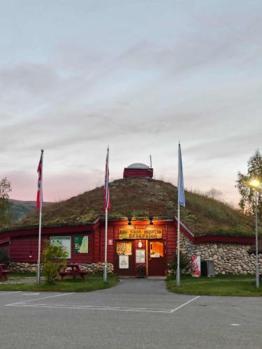 a building with a grass roof with flags on it at Nordnes Kro og Camping in Rokland