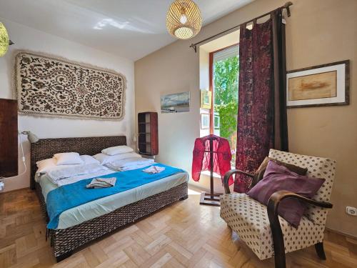 a bedroom with a bed and a chair and a window at Art Styles Boutique Apartment Szentendre in Szentendre