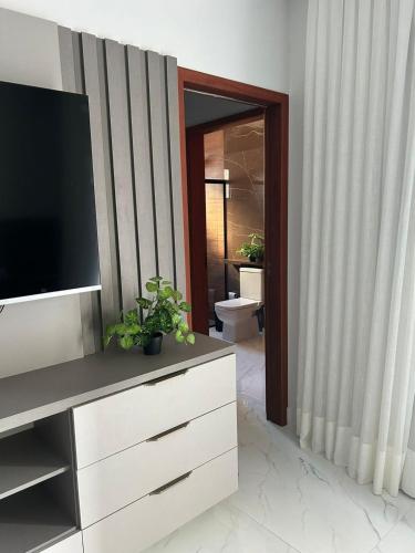 a living room with a television on a dresser at Casa Lírio Bananeiras in Bananeiras