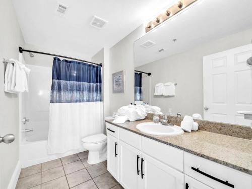 ein Badezimmer mit Waschbecken, Toilette und Dusche in der Unterkunft Laketown Wharf 1213 in Panama City Beach