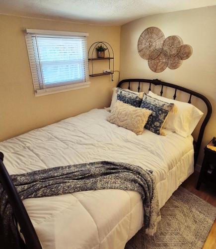 a bedroom with a bed with pillows and a window at Parkview Boho Cottage 3 - Maple Meadows in Leamington