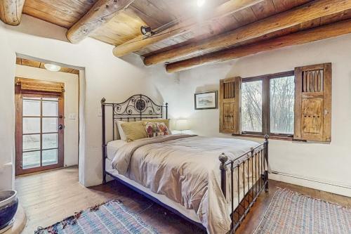 een slaapkamer met een bed in een kamer met houten plafonds bij Historic Hacienda in Ranchos de Taos
