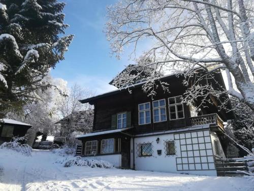a black and white house in the snow at Villa Momo in Kitzbühel