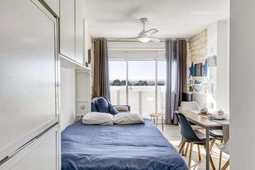Un dormitorio con una cama, un escritorio y una mesa. en Ventana Loft, en Empuriabrava