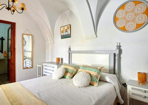 ein Schlafzimmer mit einem Bett mit weißen Laken und Kissen in der Unterkunft El Retiro Vivienda Rural in Villanueva del Rey