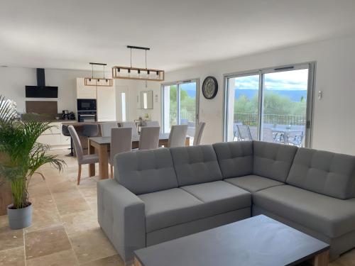 a living room with a couch and a table at La Villa Haute - Maison De Vacances in Mormoiron