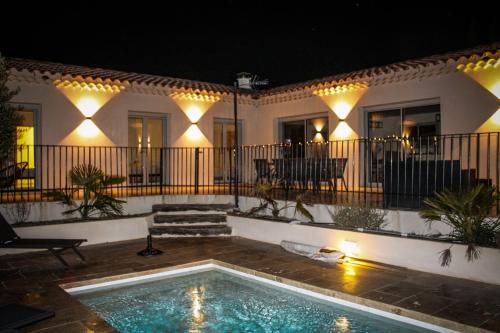 a swimming pool in front of a house at night at La Villa Haute - Maison De Vacances in Mormoiron