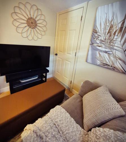a living room with a couch and a flat screen tv at Parkview Boho Cottage 3 - Maple Meadows in Leamington