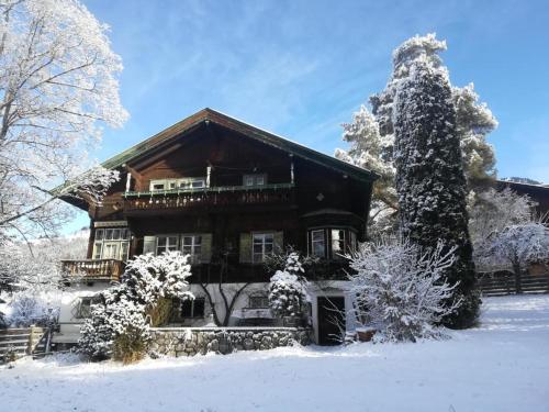 a large house with snow on the ground at Villa Momo in Kitzbühel