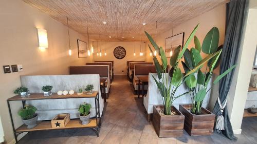 uma sala de jantar com mesas e vasos de plantas em Hotel Bahia Redonda em El Calafate