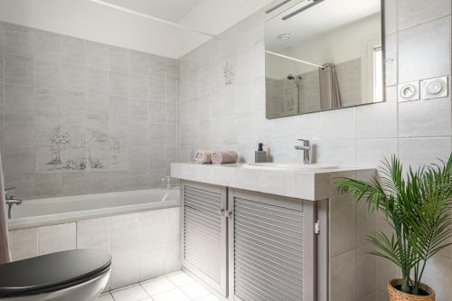 a bathroom with a sink and a toilet and a tub at Le Cocon des Allamandières in Chonas-lʼAmballan