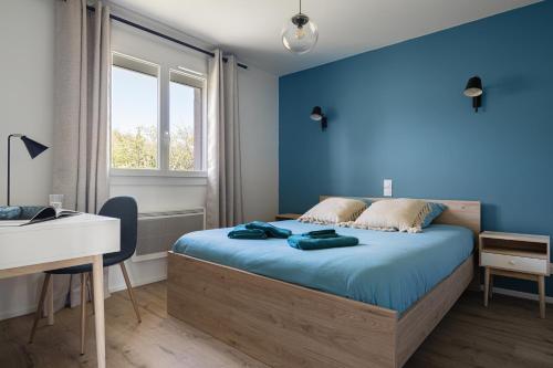 a bedroom with blue walls and a bed with a desk at Le Cocon des Allamandières in Chonas-lʼAmballan