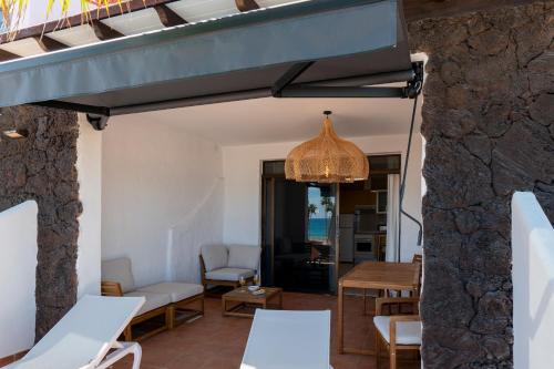 a living room with a table and chairs and a chandelier at Gold View in Costa Calma